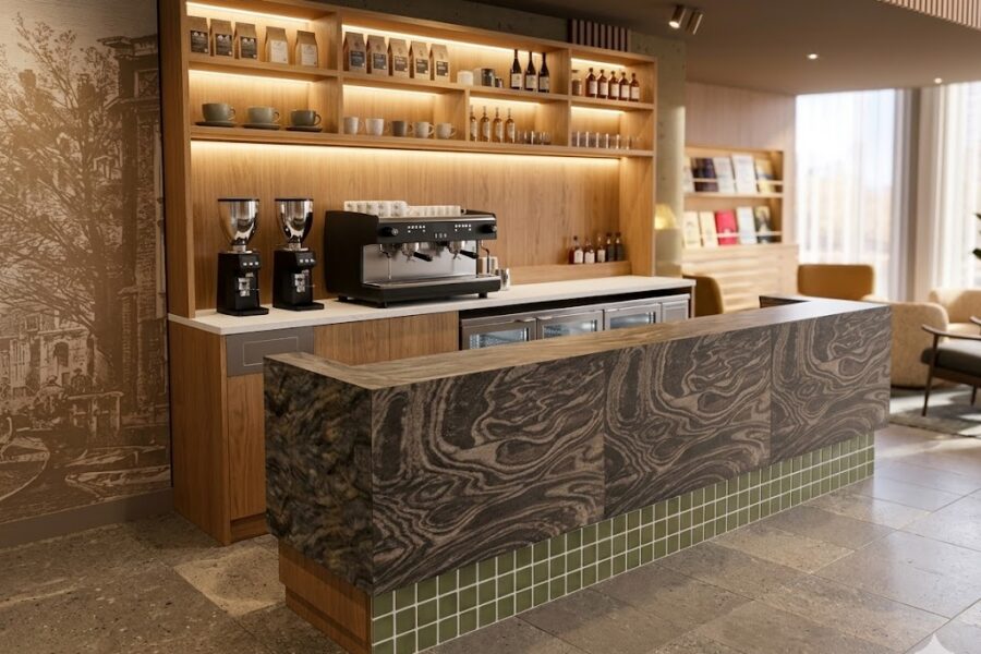 Café front bar in Rotterdam: a stone-clad counter with a green tiled plinth, and a timber barista station with espresso machine and grinders behind it.